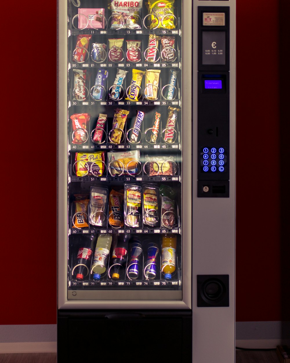 Snack vending machine stocked with chips, candy, and drinks